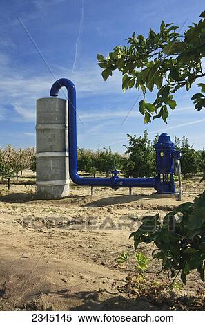 Stock Photography - Agriculture - Electric powered irrigation water pump and standpipe in an orange grove / near Dinuba, California, USA.. Fotosearch