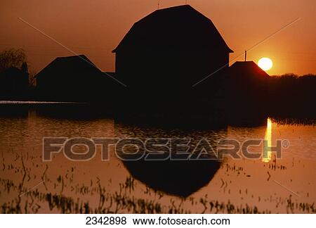 Agriculture - Silhouette of a barn at sunset reflected in a pond / Wisconsin, USA. View Large Photo Image Stock Photo - Agriculture - Silhouette of a barn at sunset reflected in a pond / Wisconsin, USA.. Fotosearch