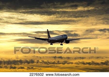 Stock Image - Airplane Approaching At Sunset.. Fotosearch