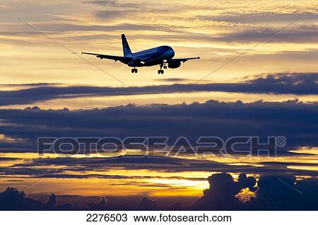 Stock Image - Airplane Approaching At Sunset.. Fotosearch