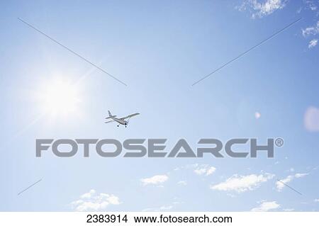 Picture - Airplane flying against a blue sky; Langley, British Columbia, Canada. Fotosearch