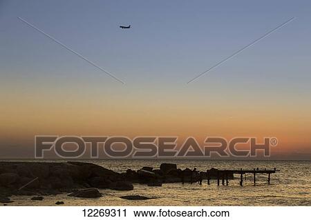 Airplane in the sky with sunset over the ocean; Paphos, Cyprus View Large Photo Image Stock Image - Airplane in the sky with sunset over the ocean; Paphos, Cyprus. Fotosearch