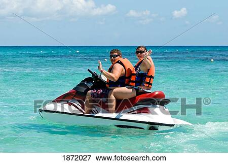 Stock Photo - Akumal, Mexico; A Man And Woman On A Personal Watercraft In The Water. Fotosearch