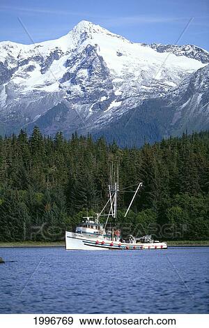 Alaska, Commercial Fishing Boat, Tender At Anchor, Snow Covered Mountain Background View Large Photo Image Stock Photo - Alaska, Commercial Fishing Boat, Tender At Anchor, Snow Covered Mountain Background. Fotosearch