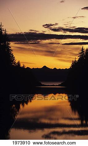 Stock Image - Alaska, Juneau, Petersen Creek, Mountains, Trees And Sunset Reflections.. Fotosearch