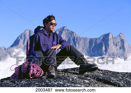 Alaska, Mendenhall Glacier, Close-Up Of Hiker Resting On Rock, Snow Covered Mountains In Background View Large Photo Image Stock Photo - Alaska, Mendenhall Glacier, Close-Up Of Hiker Resting On Rock, Snow Covered Mountains In Background. Fotosearch