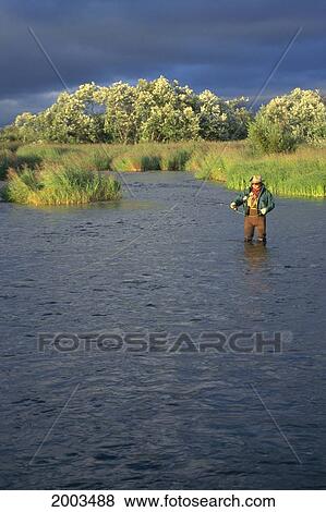 Alaska, View Of Man Standing In River Fishing, Grey Waters View Large Photo Image Stock Photo - Alaska, View Of Man Standing In River Fishing, Grey Waters. Fotosearch