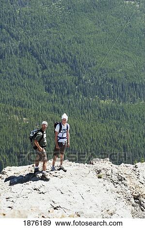 Alberta, Canada; Two Hikers On Nahahi Ridge With The Valley Below In Kananaskis Country View Large Photo Image Stock Photo - Alberta, Canada; Two Hikers On Nahahi Ridge With The Valley Below In Kananaskis Country. Fotosearch