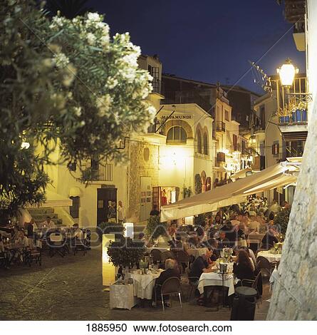 Stock Image - Alfresco Cafes In Town Square At Dusk. Fotosearch