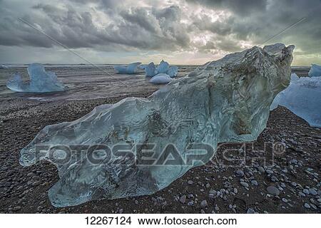 Along the south shore of Iceland, large chunks of ice litter the beach after being washed out to sea from the Jokulsarlon lagoon; Iceland View Large Photo Image Picture - Along the south shore of Iceland, large chunks of ice litter the beach after being washed out to sea from the Jokulsarlon lagoon; Iceland. Fotosearch