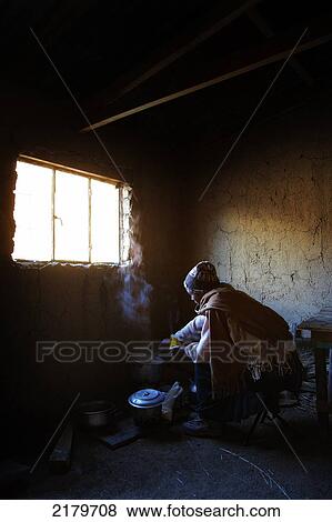 Stock Photo - Amaryan woman cooking in village hut; Cordillera Real, Bolivia. Fotosearch