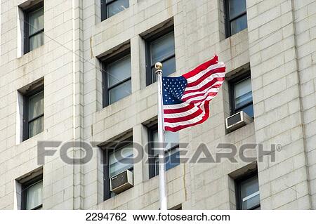 Stock Image - American Flag Waving In Front Of A Building Facade, Manhattan, New York, Usa. Fotosearch