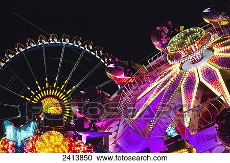 Stock Image - Amusement park rides illuminated at nighttime; Munich, Germany. Fotosearch