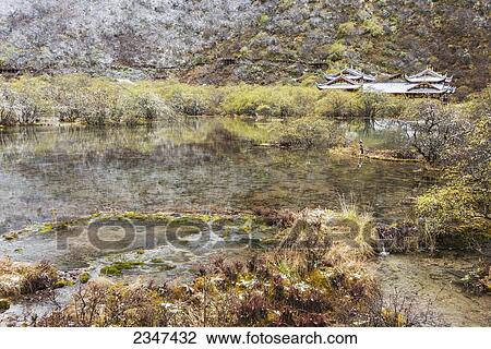 Stock Image - An Ancient Tibetan Buddhist Temple In A Green Valley With Colorful Ponds And Brooks; Huanglong, Sichuan Province, China. Fotosearch