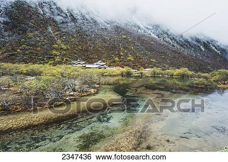 Stock Photograph - An Ancient Tibetan Buddhist Temple In A Green Valley With Colorful Ponds And Brooks; Huanglong, Sichuan Province, China. Fotosearch