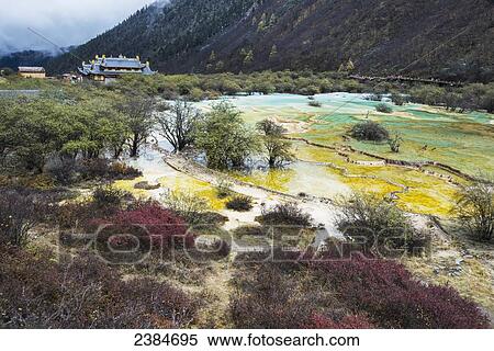 Stock Photography - An ancient Tibetan Buddhist temple in a green valley with colourful ponds and brooks; Huanglong, Sichuan province, China. Fotosearch