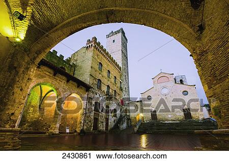Stock Image - An arched stone wall over a walkway; San Gimignano, Tuscany, Italy. Fotosearch