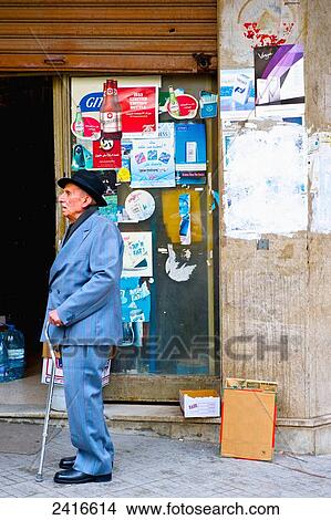 Picture - An elderly gentleman with a cane walks on an urban street; Beirut, Lebanon. Fotosearch