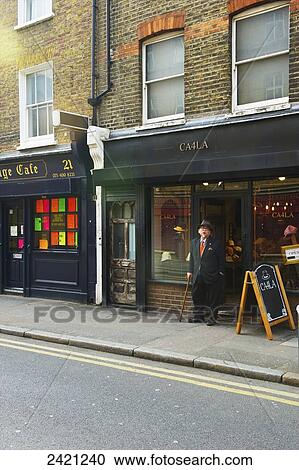 An elderly man with cane and top hat stands outside a restaurant, Shoreditch; London, England View Large Photo Image Stock Image - An elderly man with cane and top hat stands outside a restaurant, Shoreditch; London, England. Fotosearch