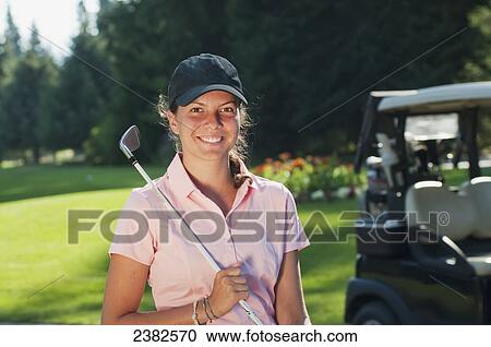 Stock Image - An enthusiastic female member of the guest services team at the Whistler Golf Course; Whistler, British Columbia, Canada. Fotosearch