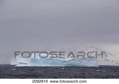 An Iceberg In The Water Off The Coast; Antarctica View Large Photo Image Stock Photo - An Iceberg In The Water Off The Coast; Antarctica. Fotosearch