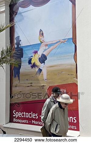 Stock Image - An old couple walk past the seafront casino. Dinard. Brittany. France.. Fotosearch