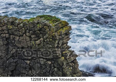 Picture - An old horizontal lava flow creates a wall of hexagonal rocks along the Strandir coast which is located in the West Fjords of northwest Iceland; Iceland. Fotosearch