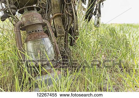 Stock Photography - An old lantern lay against a post in rural Saskatchewan; Val Marie, Saskatchewan, Canada. Fotosearch