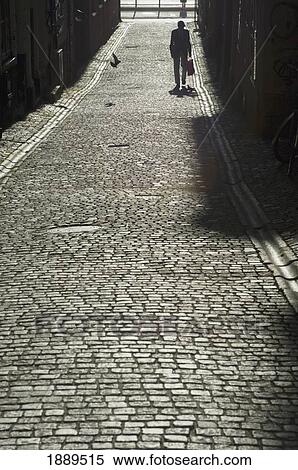 An Old Man Walking Along A Cobbled Street. View Large Photo Image Stock Photography - An Old Man Walking Along A Cobbled Street.. Fotosearch