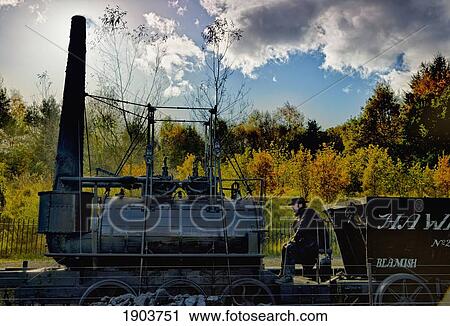 Stock Image - An Old Steam Engine On A Locomotive With A Driver; Beamish, Durham, England. Fotosearch