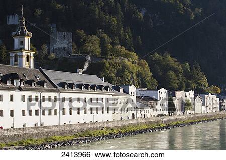 An old town along a river with stone barrier and church steeple with castle and mountains, tree covered slope in the background; Rattenberg, Austria View Large Photo Image Stock Photograph - An old town along a river with stone barrier and church steeple with castle and mountains, tree covered slope in the background; Rattenberg, Austria. Fotosearch