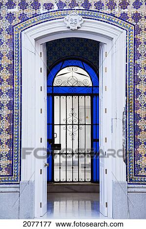 An Open Doorway On A Building With Ornate Facade Leading Into A Room With A Gate Surrounded By Blue Glass; Chiclana De La Frontera Andalusia Spain View Large Photo Image Stock Photo - An Open Doorway On A Building With Ornate Facade Leading Into A Room With A Gate Surrounded By Blue Glass; Chiclana De La Frontera Andalusia Spain. Fotosearch