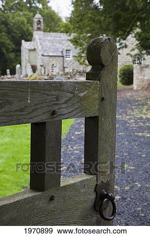 Stock Photo - An Open Gate Leading Down A Path To A Cemetery And Church; Northumberland England. Fotosearch