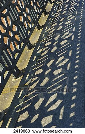 Stock Image - An ornate metal fence and it's shadow on the ground; Hamburg, Germany. Fotosearch