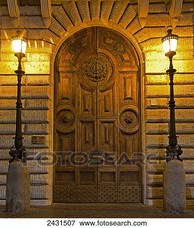 An ornate wooden door with illuminated lamp posts, Piazza Navona; Rome, Italy View Large Photo Image Stock Photo - An ornate wooden door with illuminated lamp posts, Piazza Navona; Rome, Italy. Fotosearch