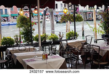 Stock Photo - An outdoor restaurant patio on a canal; Venice, Italy. Fotosearch