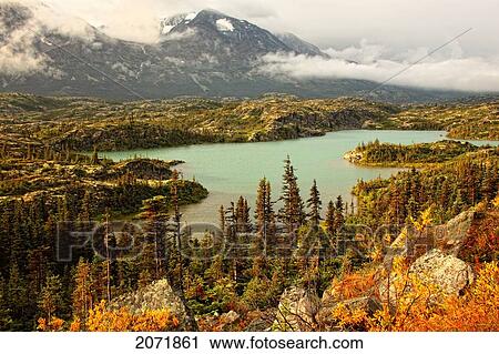 Stock Image - An Unnamed Lake With The Tundra In Fall Colours, Near The British Columbia-Yukon Border. Fotosearch