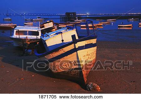 Stock Photography - Andalusia, Spain; A Boat On The Shore And Boats In The Water Near Chiclana. Fotosearch