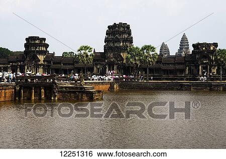 Stock Photograph - Angkor Wat main temple, people walking over causeway; Siem Reap, Cambodia. Fotosearch