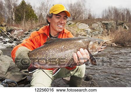 Stock Photograph - Angler holding a large brook trout (Salvelinus fontinalis); Ontario, Canada. Fotosearch