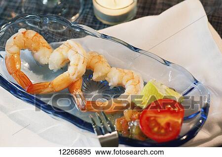 Stock Photography - Appetizer for two, a romantic themed menu item of fresh shrimp cocktail arranged to look like a pair of hearts for a light start to a date night meal; Fort McMurray, Alberta, Canada. Fotosearch