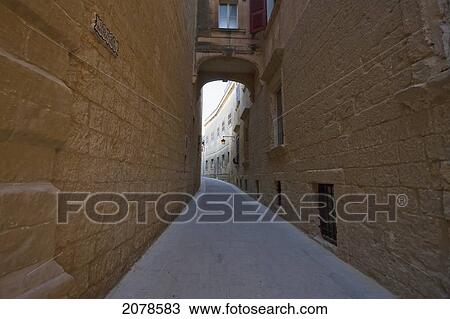 Arch Between Stone Houses Over A Narrow Street, Mdina, Malta View Large Photo Image Stock Image - Arch Between Stone Houses Over A Narrow Street, Mdina, Malta. Fotosearch