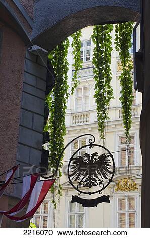 Stock Image - Archway With Austrian Flags, Austrian Eagle And Descending Plants, Vienna, Austria. Fotosearch