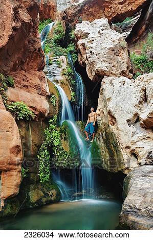 Picture - Arizona, Grand Canyon National Park, Young Man Standing Above The Waterfall At Elves Chasim.. Fotosearch