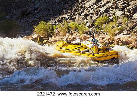 Stock Image - Arizona, Grand Canyon National Park, Man Rafting On The Colorado River, Large Rapids. Editorial Use Only.. Fotosearch