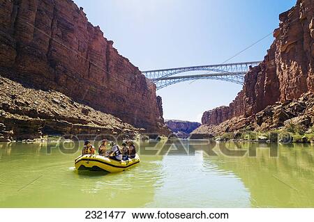 Stock Photo - Arizona, Grand Canyon National Park, Friends Rafting On The Colorado River Under Bridge. Editorial Use Only.. Fotosearch