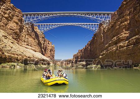 Stock Photo - Arizona, Grand Canyon National Park, Friends Rafting On The Colorado River Under Bridge. Editorial Use Only.. Fotosearch