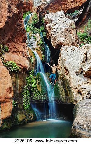 Stock Photography - Arizona, Grand Canyon National Park, Young Man Standing Above The Waterfall At Elves Chasim.. Fotosearch