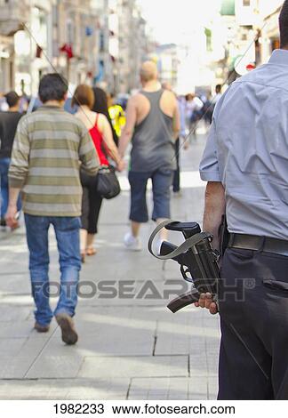 Stock Image - Armed Guard Picking Up Money From A Retail Store; Instanbul Turkey. Fotosearch