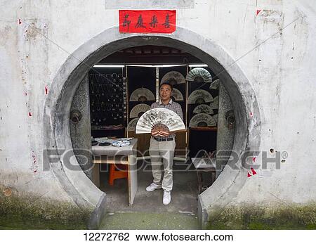 Artist holding a fan with a traditional Chinese brush painting, Xidi, Anhui, China View Large Photo Image Stock Image - Artist holding a fan with a traditional Chinese brush painting, Xidi, Anhui, China. Fotosearch